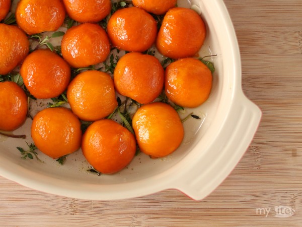 Halved and Peeled Apricots Arranged on a Bed of Herbs